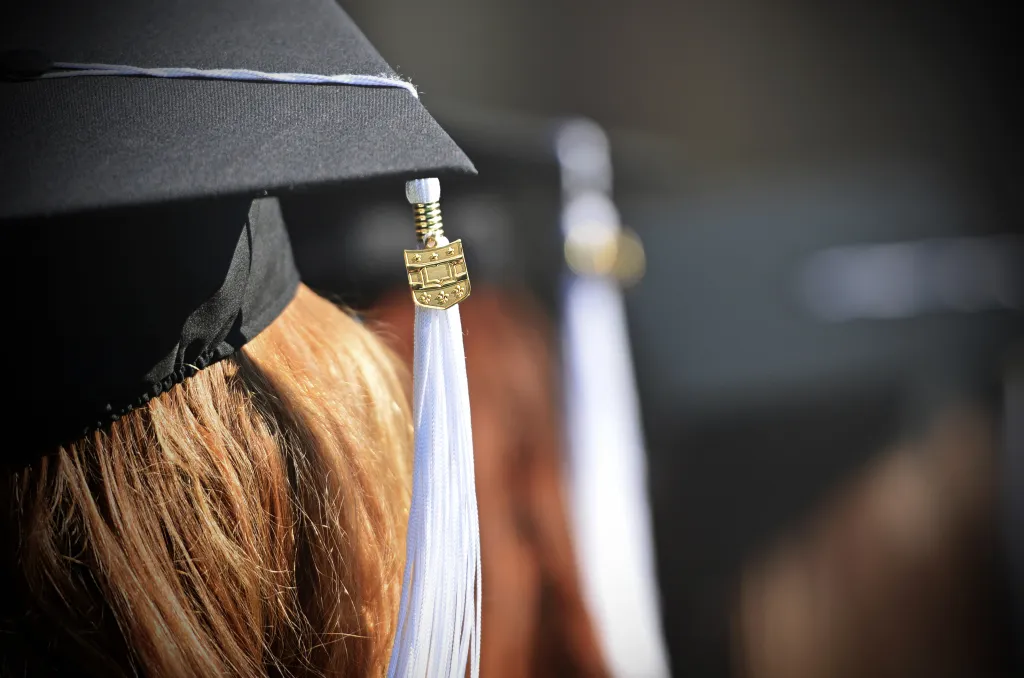 A close-up photo of a student's mortarboard and tassel at a graduation ceremony
